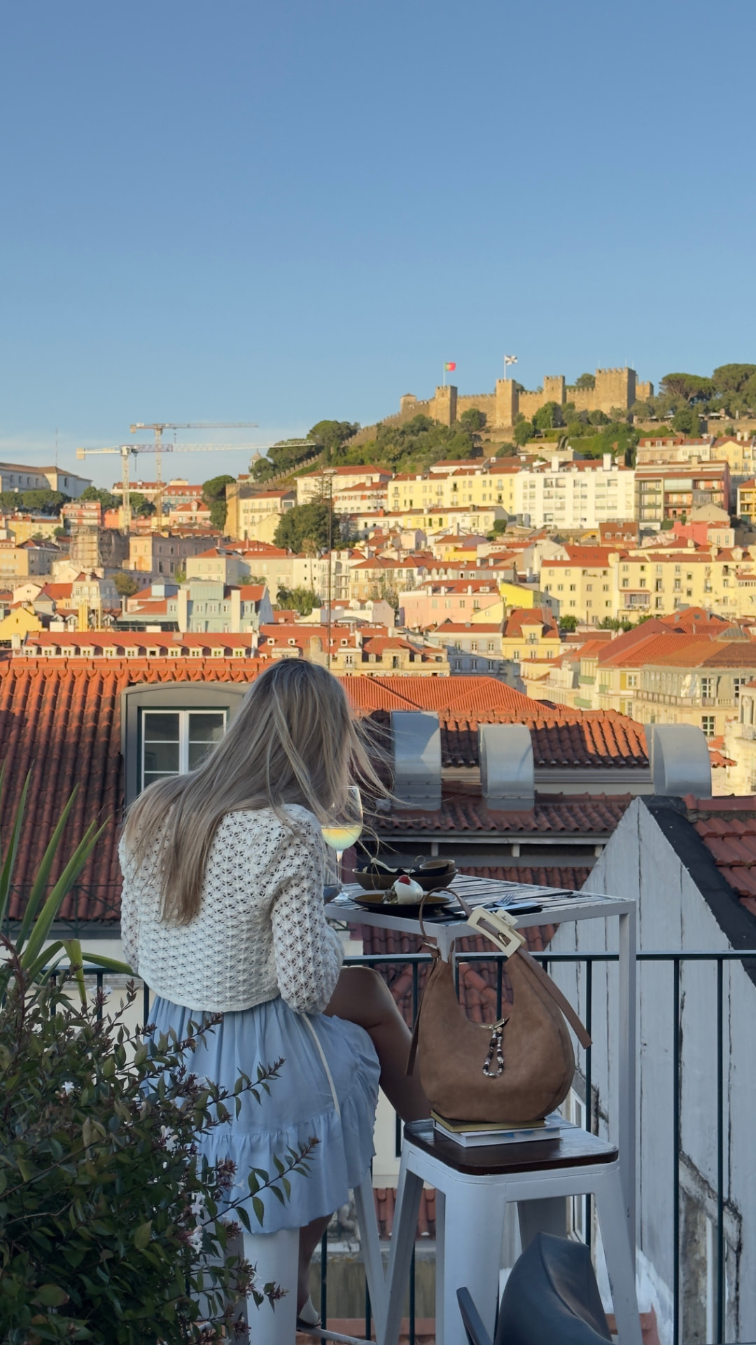 A guest at The Art Inn rooftop looking toward São Jorge Castle across the Lisbon rooftops